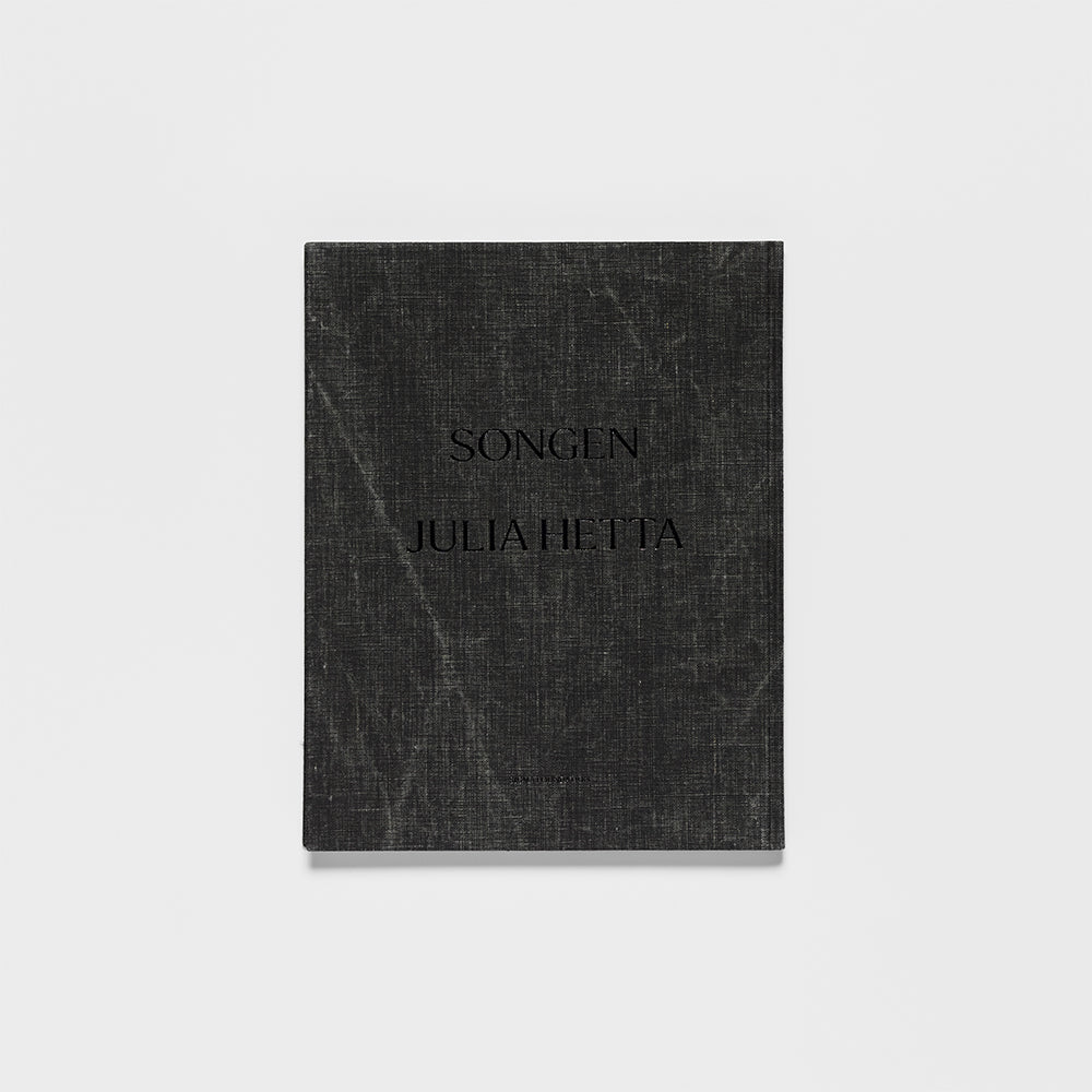 Cover of the book "Songen" by Julia Hetta: textured dark‑gray cover with embossed title SONGEN JULIA HETTA.