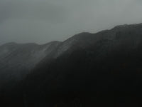 Dark mountain ridges fading into a hazy gray sky.
