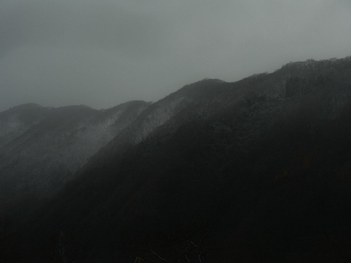 Dark mountain ridges fading into a hazy gray sky.